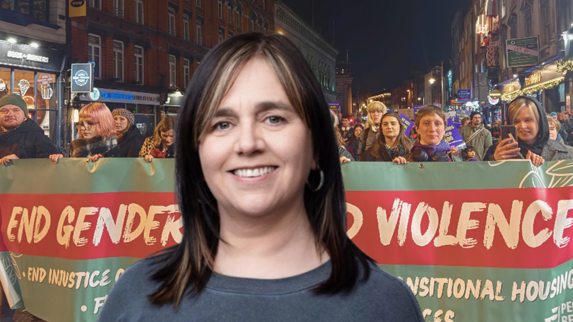 Melisa Halpin in front of a banner reading End Gender Based Violence.