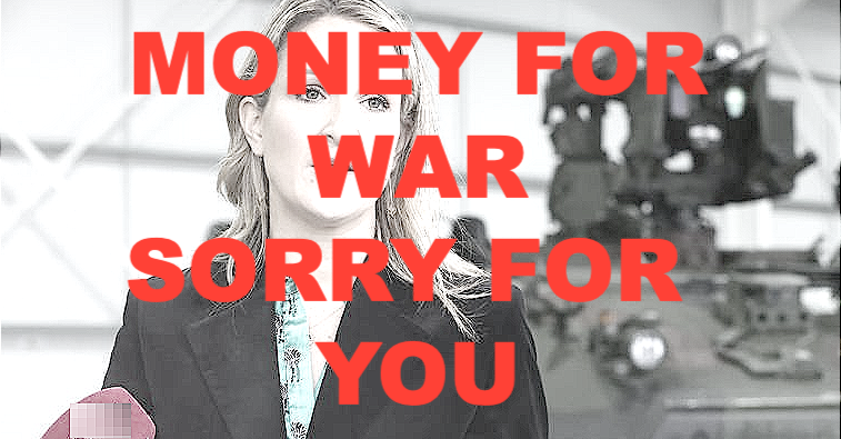 Minister Helen McEntee next to an armoured personel carrier overwritten with Money For War Sorry For You.
