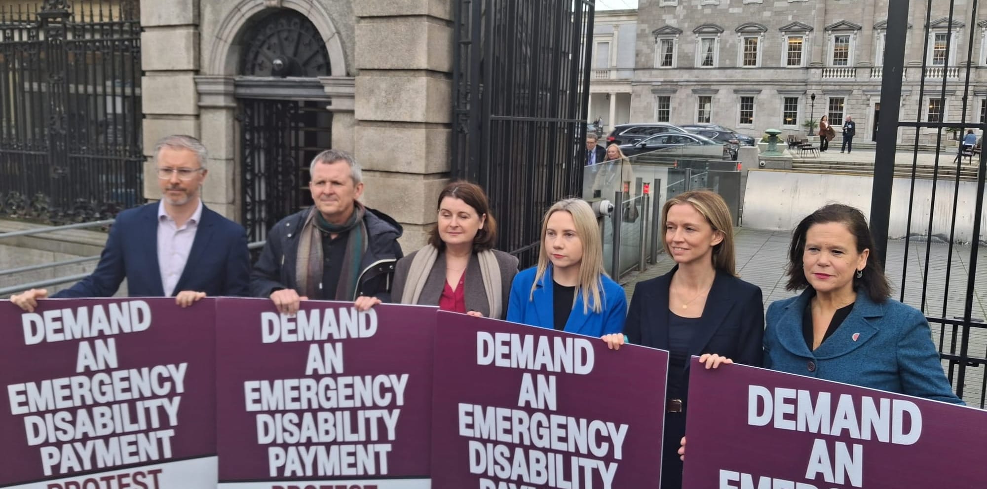 Party reps and leaders stand with Richard Boyd Barrett behind placards saying Demand An Emergency Disability Payment, advertising the protest this weekend. 