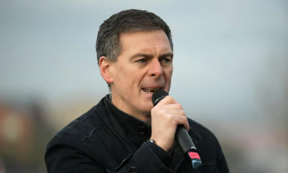 Shaun Harkin speaking outdoors 