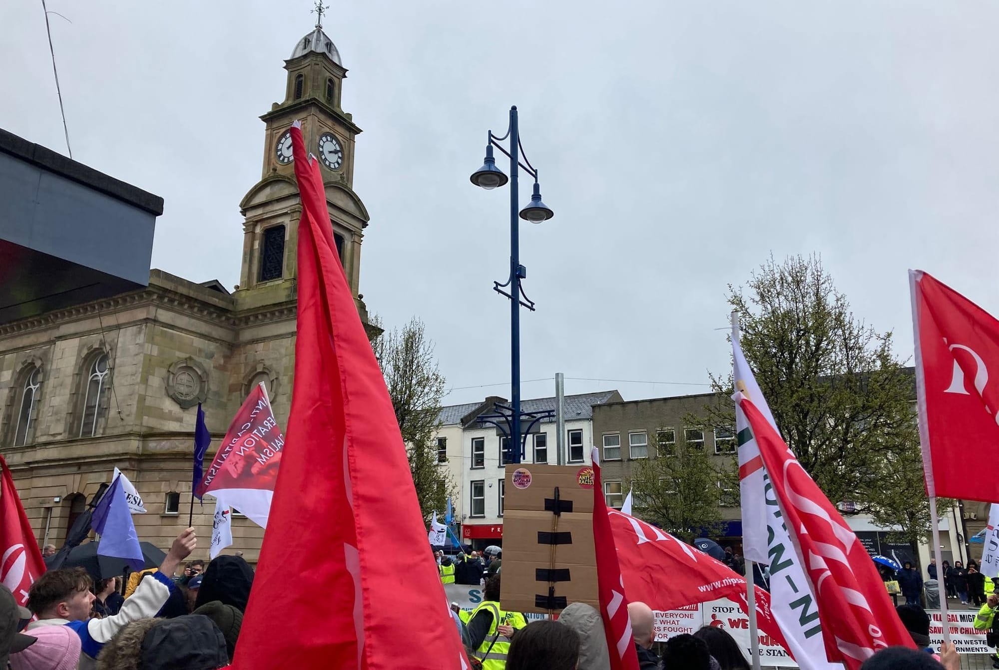 View of the counter protest with union flags prominent in front of landmark Coleraine Town Hall.