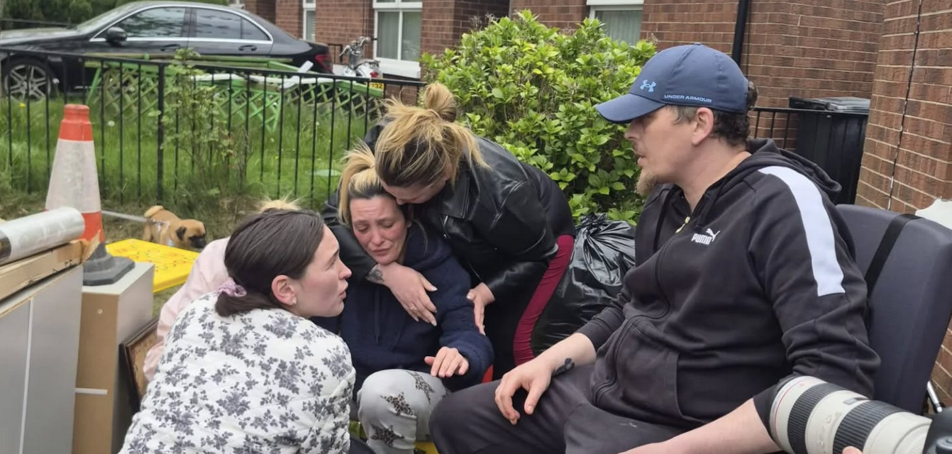 The family and supporters outside their home surrounded by their removed belongings.