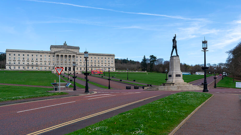 Empty roads around Stormont with a Give Way sign and the statue of Carson