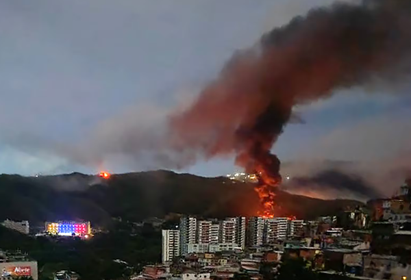 Screenshot of image on the Irish Times Website saying: 'Fire at Fuerte Tiuna, Venezuela's largest military complex, is seen from a distance'