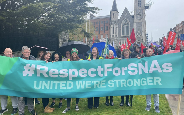 SNAs behind a Fórsa union banner saying #RespectForSNAs United We're Stronger at a Dublin march