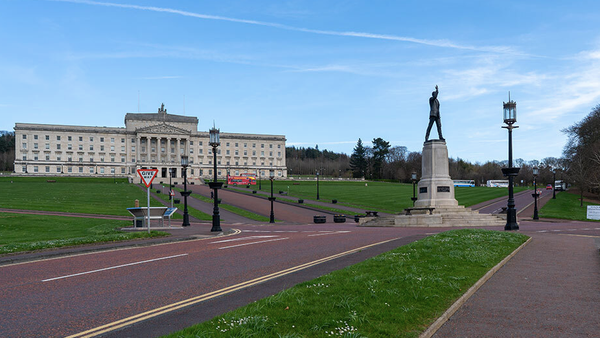 Empty roads around Stormont with a Give Way sign and the statue of Carson