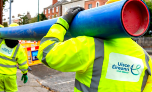 Water service workers for Uisce Éireann carrying pipe.